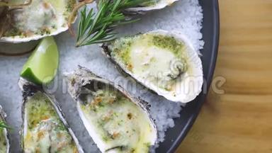 用奶酪、石灰和香草在盘子里烤的牡蛎。 赠送菜单海鲜餐厅.. 地中海美食。 服务对象